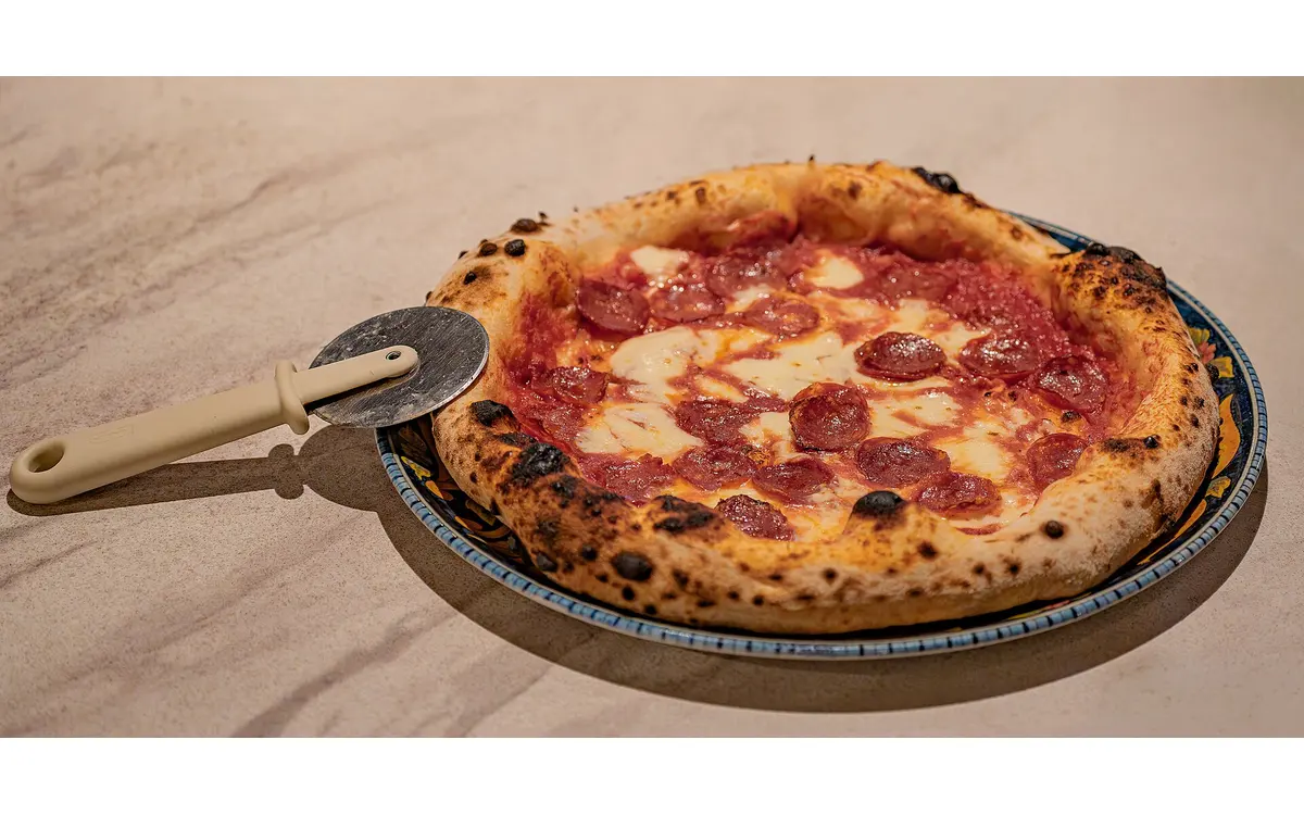 Pizza com queijo derretido e cobertura generosa